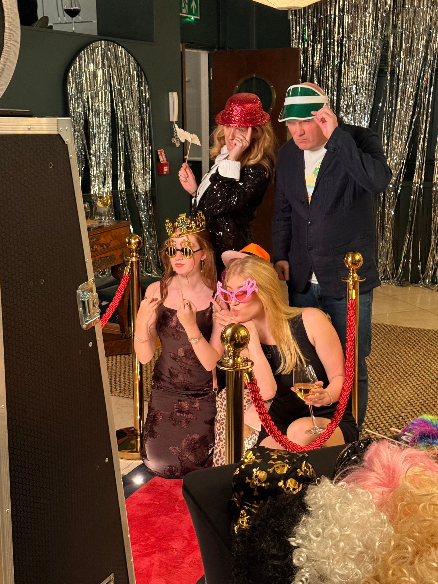 Guests in props and costumes posing at the mirror booth