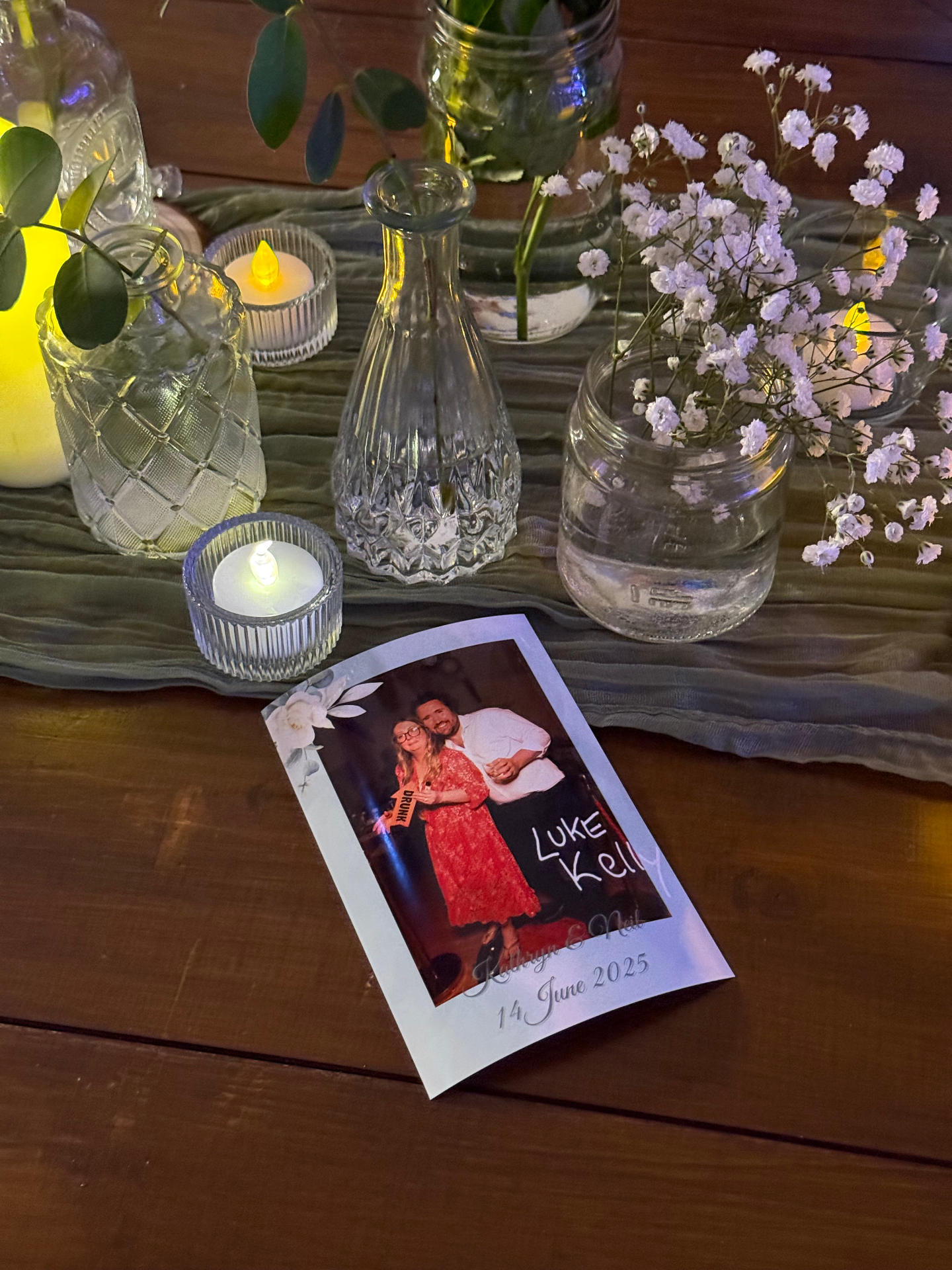 Custom-branded wedding photo booth print on a candlelit table